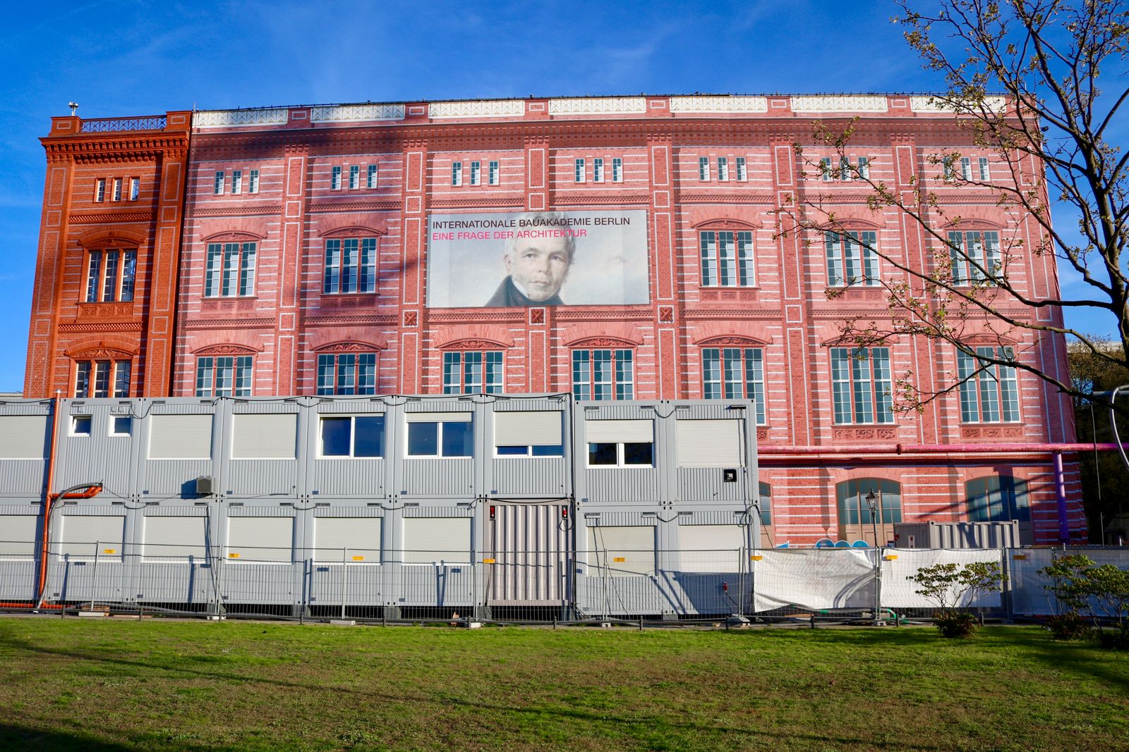 Rote Ziegelfassade der Berliner Bauakademie mit charakteristischer Rasterstruktur und Sandsteindetails